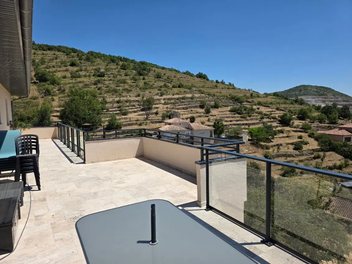 Garde-corps vitré sur une terrasse dominant les causses