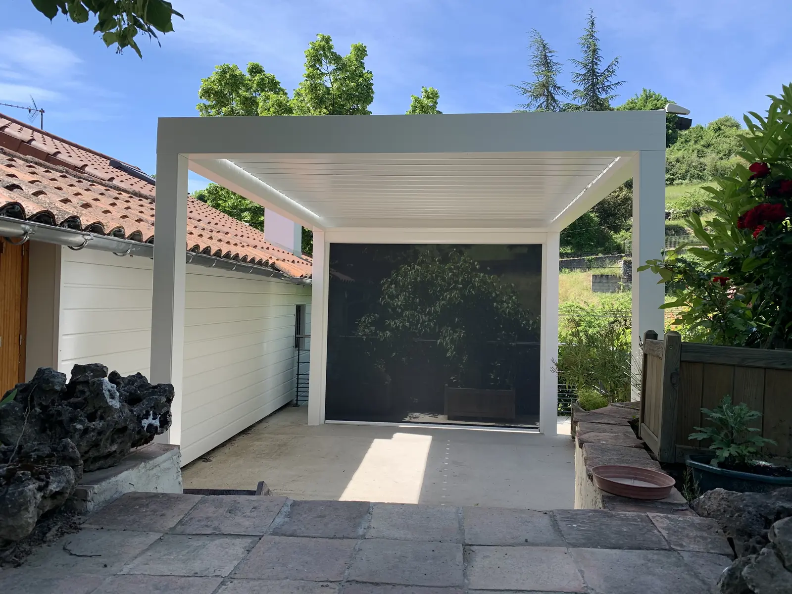 Pergola bioclimatique blanche installée sur une terrasse